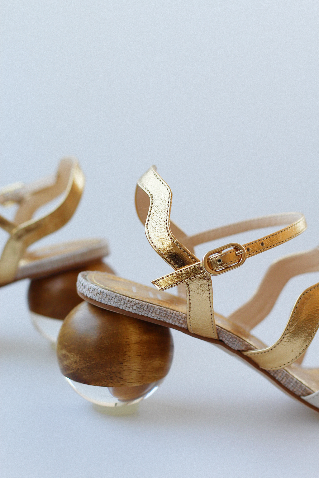 Gaspea sandal in gold and off-white with acrylic sphere heel and chestnut wood.