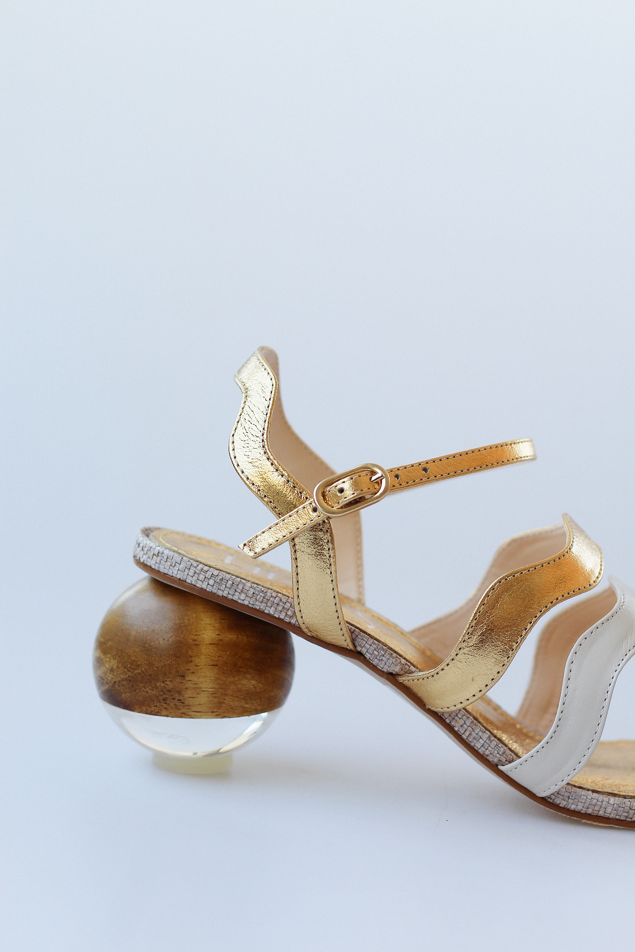 Gaspea sandal in gold and off-white with acrylic sphere heel and chestnut wood.